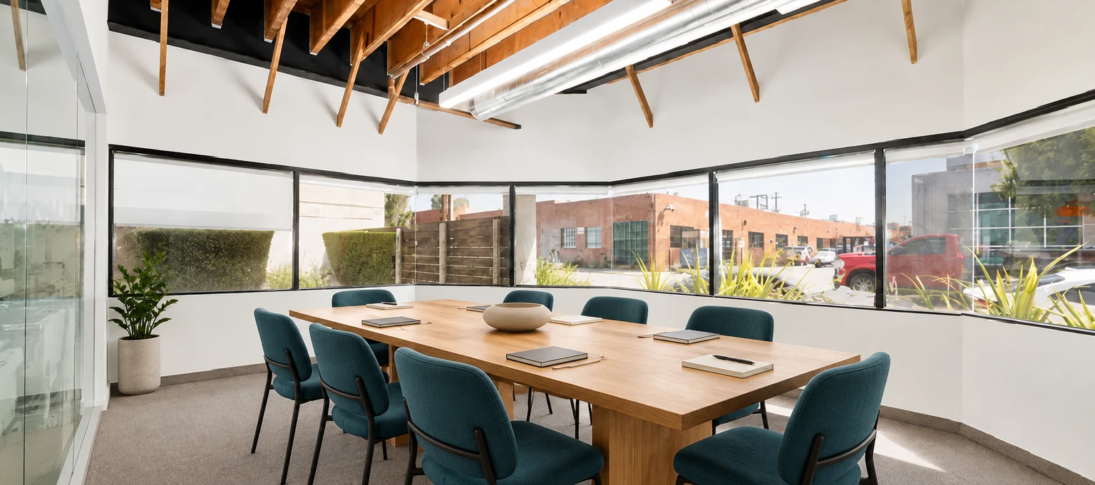 Conference table and teal chairs in Westgate’s window-lined corner room