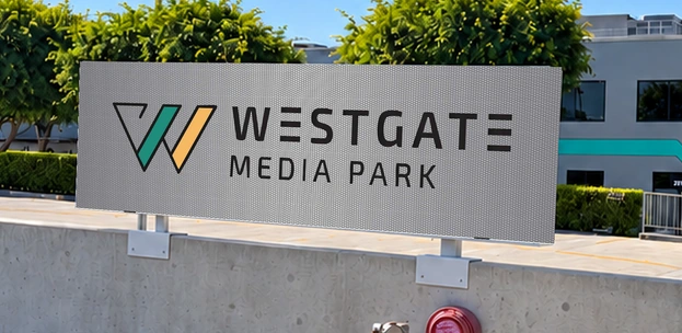 Westgate Media Park horizontal sign in teal, gold and perforated silver